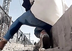 The very hopeless woman was pissing in her jeans beside the railroad tracks