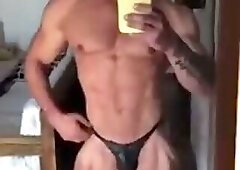 Guy in Black Posing Trunks In Front Of A Mirror