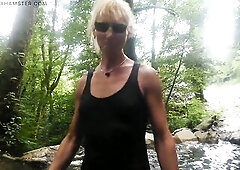 Alexa Cosmic trans hotty swimming in font near waterfall wearing shorts and t-shirt...