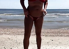 Floozy flashing booty and snatch at beach