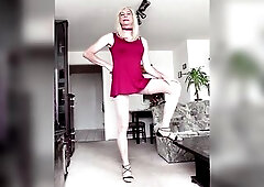 Trtansvestite at home in short suit and high heels