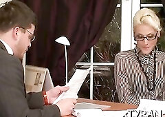 Outstanding blond woman in shoes with high heels is into femdom sessions whilst at work