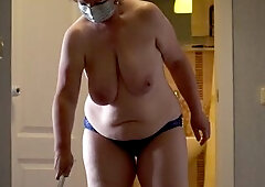 A mature, fat milf with big, natural, saggy tits is cleaning the apartment.