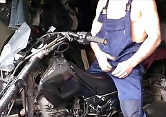 A bulky mechanic gets revved on at work and has hookup with a motorcycle whilst repairing it