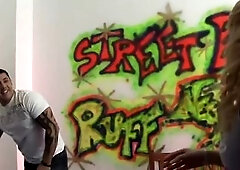 In front of a neon graffiti wall a golden-haired with large round bazookas and ebony lace-top nylons sucks the man in the white shirt. That babe rides