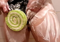 Curvy tattooed Asian woman teases with a soapy loofah in a steamy bathroom
