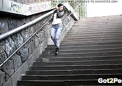 This raven haired honey is walking throughout the town and needs to pee desperately so stops near the bottom of some steps to relieve herself and ends