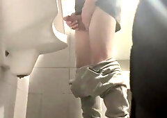 two folks in sneakers having joy at public toilets' urinal