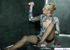 Beautiful teacher in satin shirt is playing with a huge ejaculating dildo through a gloryhole