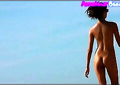 Naked people are enjoying on the nudist beach, even though someone might be staring at them