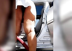 Aged woman pissing peeing in a public carwash parking lot