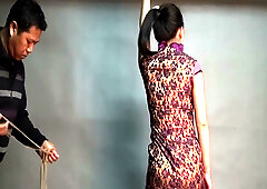 Brunette bound in intricate rope harness for suspended bdsm session
