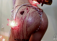 Small-breasted woman with glowing fairy lights toys with herself on the wooden floor